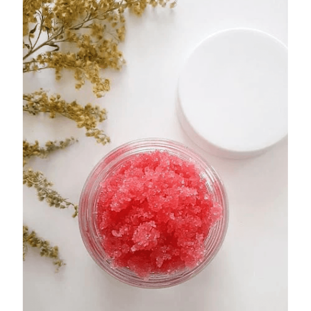 Lip Therapy Scrub open jar with pink sugar scrub and dried flowers flatlay
