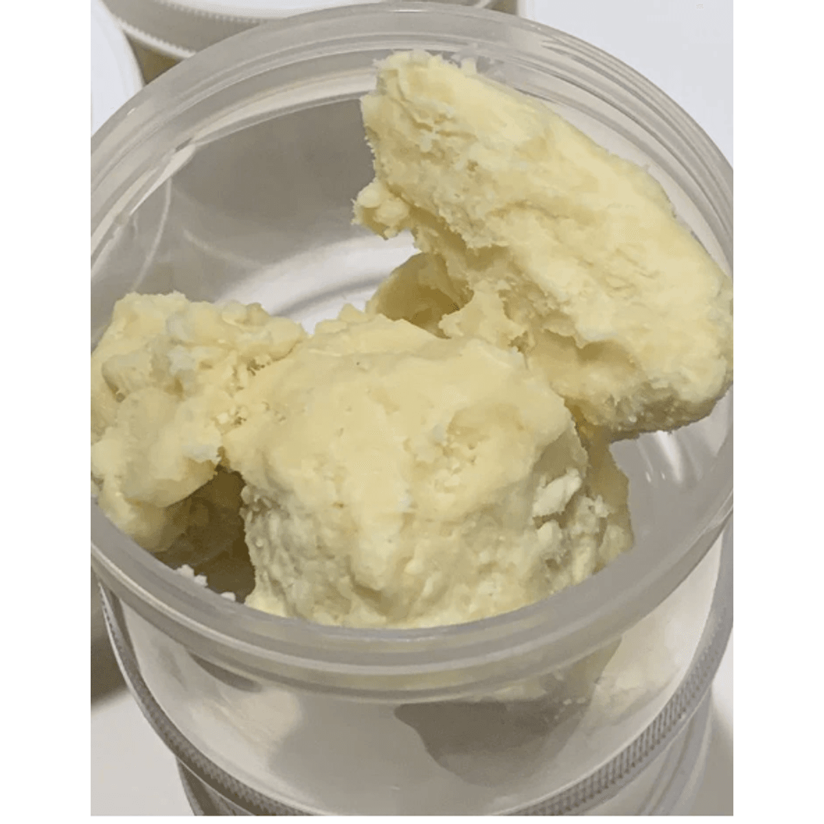 Raw shea butter in open 1L container — pure and unrefined